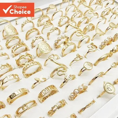 Bandeja branca com dezenas de anéis dourados de modelos variados, com borboleta, pérolas, serpente e medalhas