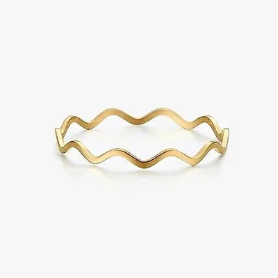 Anel fino dourado com formato de onda contínua, liso e polido, sobre fundo branco