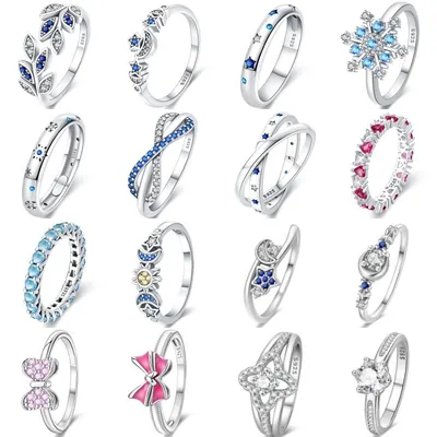 Dezesseis anéis de prata com pedrinhas azuis, rosas e brancas: lua, estrelas, laço, infinito, floco de neve e solitário