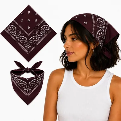 Bandana marrom escuro com estampa paisley branca, aberta, dobrada e amarrada na cabeça de uma mulher