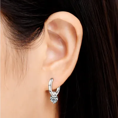 Orelha com brinco argola prateada pequena e uma moissanite redonda presa em garras pendurada embaixo
