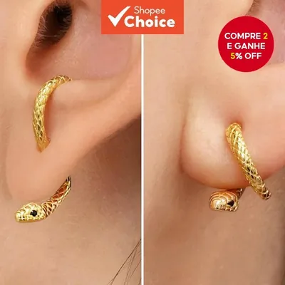 Orelha com brinco dourado em forma de cobra com escamas, corpo contornando o lóbulo e cabeça aparecendo embaixo