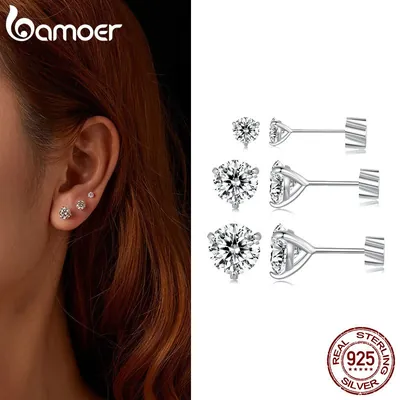Orelha com três brincos de moissanite em tamanhos diferentes e três pares de prata 925 vistos de frente e de lado