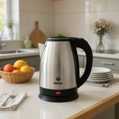 Chaleira elétrica de aço inox com alça, tampa e base pretas sobre bancada clara de cozinha, com frutas e pratos ao fundo