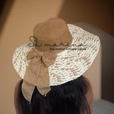 Mulher de costas usando chapéu de aba larga creme e caramelo, copa trançada e laço de tecido marrom pendente