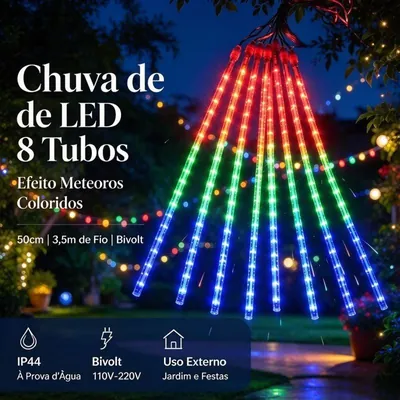 Oito tubos de LED pendurados em galho de árvore à noite, com luz em degradê vermelho, laranja, verde e azul num jardim