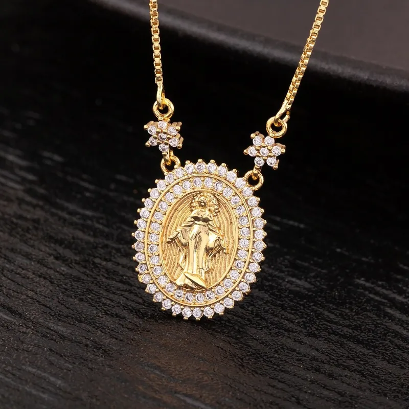 Medalha oval dourada com Virgem Maria em relevo, moldura de pedrinhas brancas e corrente veneziana sobre madeira escura
