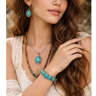 Mulher de chapéu de palha usando brincos, colar e pulseira com pedras ovais cor turquesa em molduras prateadas trabalhadas