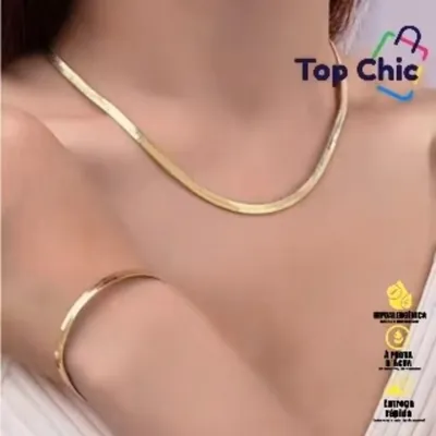 Colar dourado plano tipo osso de cobra rente ao pescoço e pulseira dourada fina no pulso de uma mulher