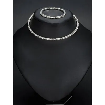 Busto de veludo preto com colar rente ao pescoço e pulseira, ambos com uma fileira contínua de strass prateado