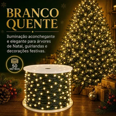 Carretel com cordão de LED de fio verde aceso em luz amarela, ao lado de árvore de Natal iluminada e presentes dourados