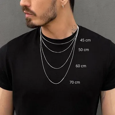 Homem de camiseta preta usando correntes venezianas finas prateadas em quatro comprimentos sobrepostos