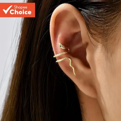 Orelha com ear cuff dourado em forma de cobra, de corpo texturizado e olhos verdes, enrolado na cartilagem