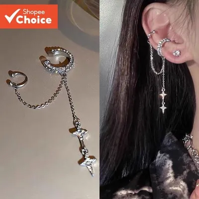 Ear cuff prateado com dois anéis de orelha ligados por corrente e pendente de duas estrelas, solto e usado na orelha