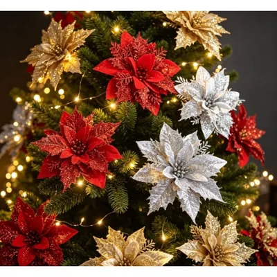 Flores de Natal artificiais vermelhas, douradas e prateadas com glitter presas aos galhos de um pinheiro com luzinhas