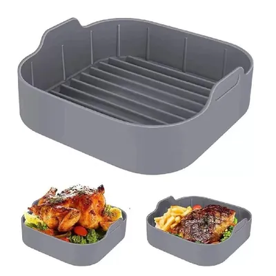 Forma de silicone cinza quadrada com cantos arredondados, frisos no fundo e alças; abaixo, frango assado e bife com fritas