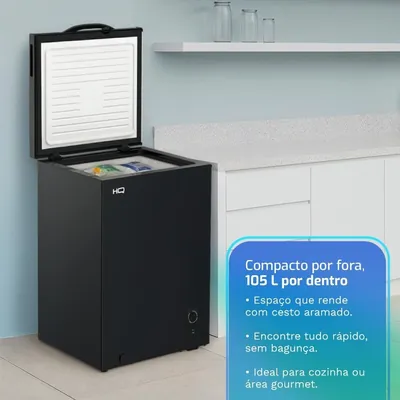 Freezer horizontal preto com tampa aberta mostrando interior branco, ao lado de bancada de cozinha com parede azul clara