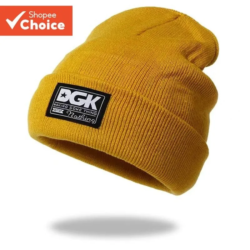 Gorro de malha canelada cor mostarda com barra dobrada e etiqueta preta retangular com as letras DGK em branco