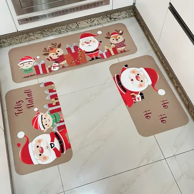 Três tapetes de cozinha bege com Papai Noel, duende, renas e presentes, dispostos no piso claro em frente à bancada
