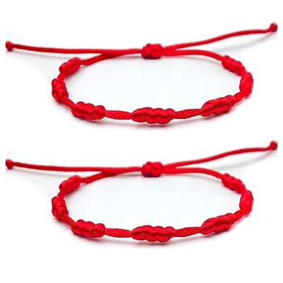 Duas pulseiras de cordão vermelho brilhante com nós ao longo do fio e fecho de nó corrediço, sobre fundo branco