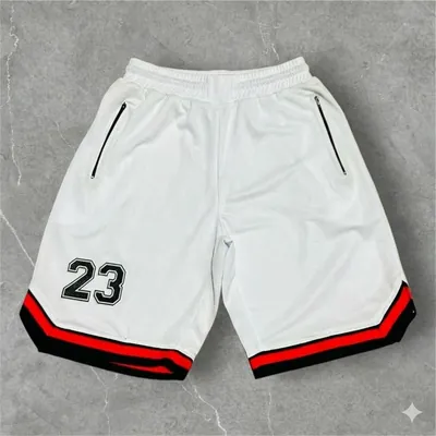 Bermudão branco estilo basquete com número 23 preto, bolsos com zíper e barra listrada em vermelho e preto