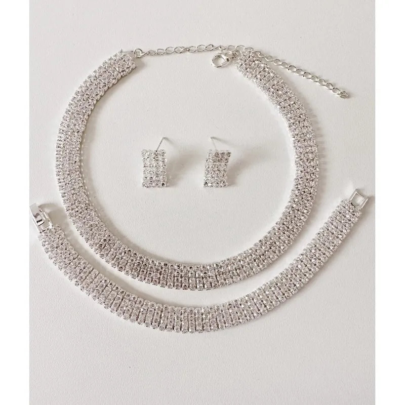 Conjunto prateado cravejado: colar rígido de fileiras de pedrinhas, pulseira igual e par de brincos retangulares