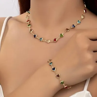 Colar rente ao pescoço e pulseira formados por corações dourados com pedras azuis, verdes, vermelhas e transparentes