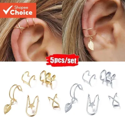 Cinco ear cuffs dourados e cinco prateados, com folha e estrela, e duas orelhas usando os modelos na cartilagem