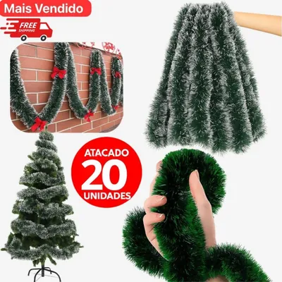 Festões verdes com pontas brancas enrolados numa árvore, presos em ondas numa parede de tijolo e segurados por uma mão
