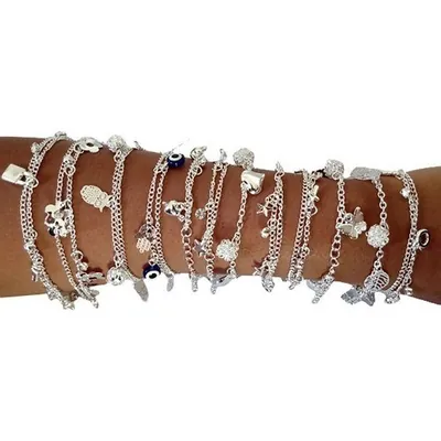 Antebraço coberto por pulseiras prateadas de corrente com berloques de coração, cadeado, olho grego, borboleta e estrela