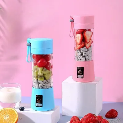 Dois mini liquidificadores portáteis, um azul e um rosa, com copos transparentes cheios de frutas picadas