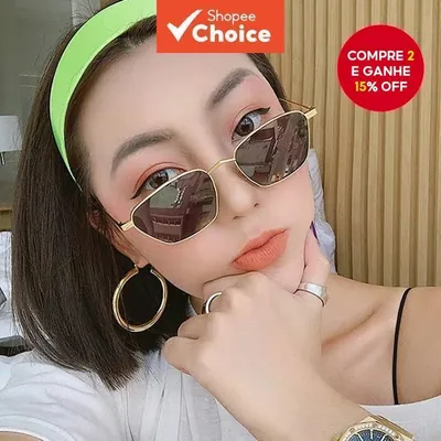 Mulher com faixa verde-neon no cabelo e argolas douradas usando óculos pequeno de metal dourado e lentes escuras