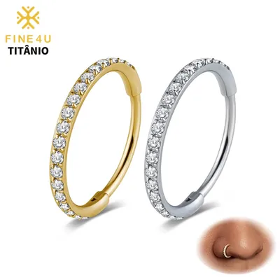 Duas argolas de piercing, uma dourada e uma prateada, com fileira de pedras brancas e detalhe usado na narina