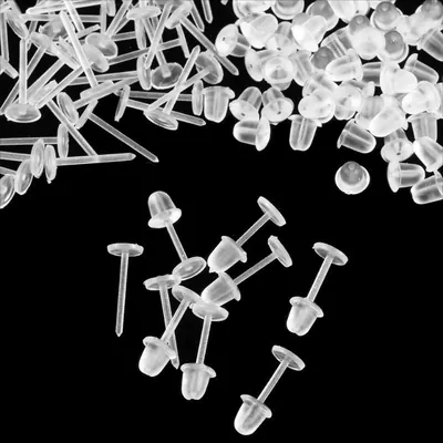 Pinos de plástico transparente com base redonda e tarraxas de silicone espalhados sobre fundo preto