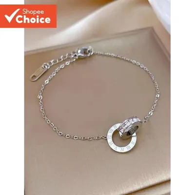Pulseira prateada de corrente fina com duas argolas entrelaçadas, uma com numerais romanos e outra com pedrinhas brilhantes