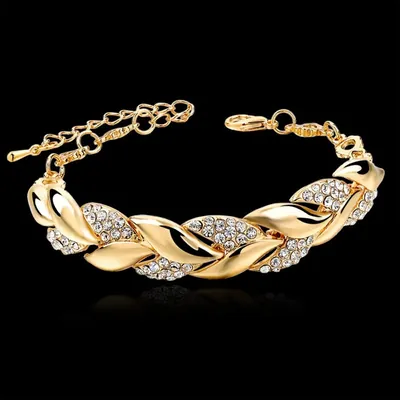 Pulseira dourada de folhas entrelaçadas, alternando folhas lisas e cravejadas de cristais, com corrente extensora