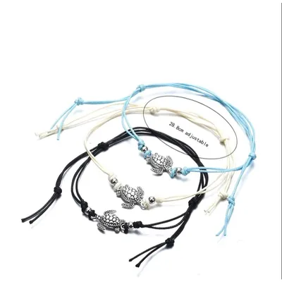 Três tornozeleiras de cordão, azul-claro, creme e preto, cada uma com tartaruga prateada e duas contas metálicas