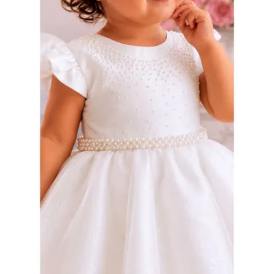 Bebê com vestido branco de corpo acetinado bordado com pérolas, cinto de pérolas e saia de tule brilhante