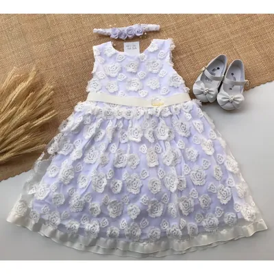 Vestido infantil branco sem manga coberto de rosas de tecido, faixa marfim na cintura, tiara e sapatinhos ao lado