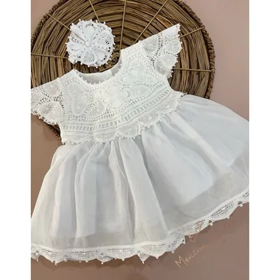 Vestido branco curto com pala e barra de renda renascença, manguinhas e flor de renda sobre bandeja de palha