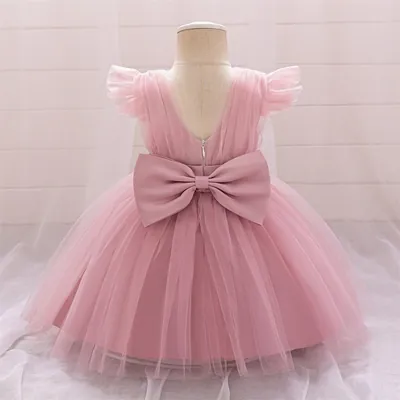 Vestido de bebê rosa em manequim visto de costas, com saia de tule, decote em V, zíper e laço grande na cintura