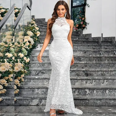 Mulher de vestido branco de renda frente única, justo até o joelho e barra sereia, em escada de mármore com rosas