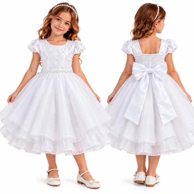 Menina de frente e de costas com vestido branco de mangas bufantes, saia de tule em camadas e laço de cetim nas costas