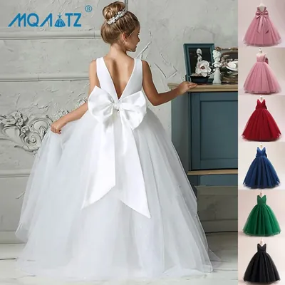Menina de costas com vestido longo branco de tule e laço grande de cetim; miniaturas do modelo em outras cores