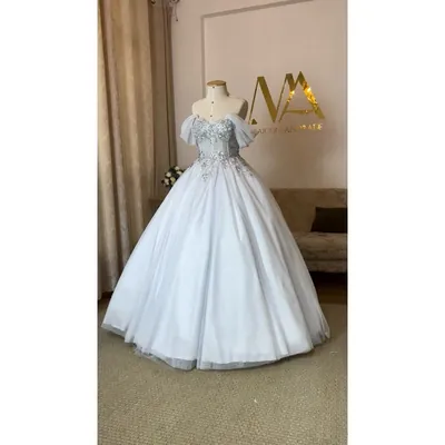 Vestido de noiva princesa em manequim, corpete bordado com brilho, mangas de tule caídas nos ombros e saia de tule ampla
