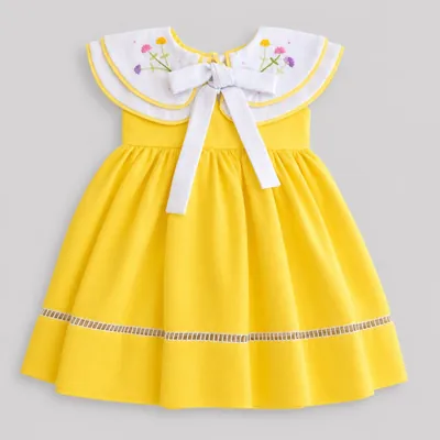 Vestido infantil amarelo sem mangas com gola branca dupla bordada com flores, laço branco e faixa vazada perto da barra
