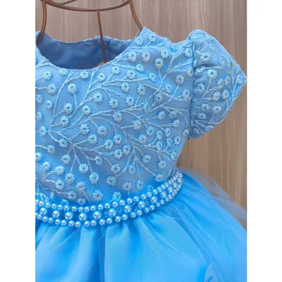 Vestido infantil azul-claro com corpo bordado de flores brancas, manga bufante, cinto de pérolas e saia de tule em cabide