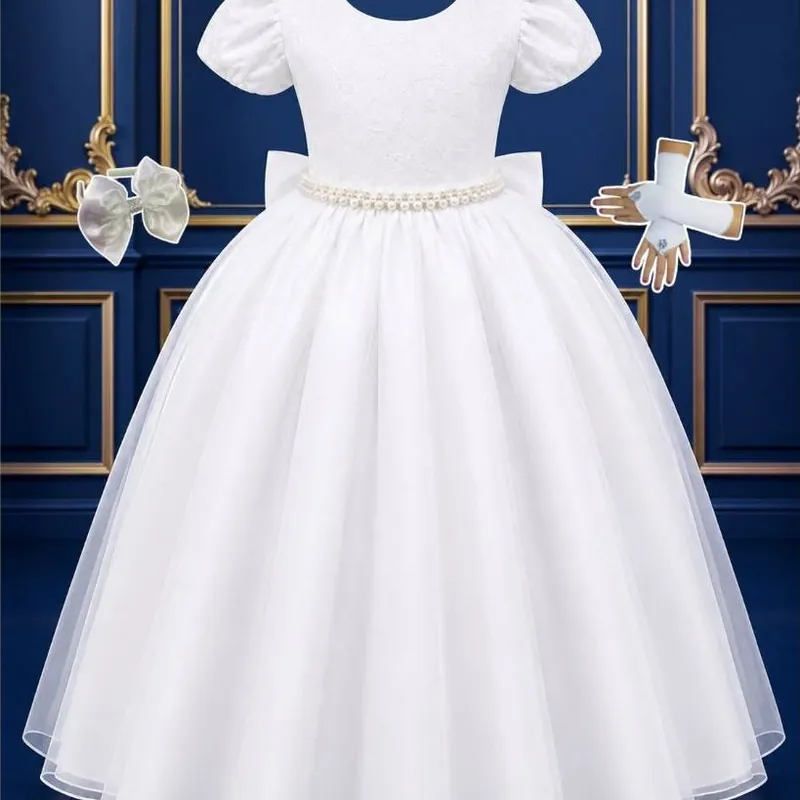 Vestido infantil branco longo com manga bufante, cinto de pérolas, laço na cintura e saia de tule, ao lado de luvas e laço