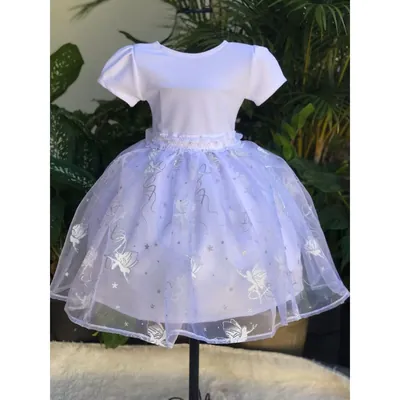 Vestido infantil branco em manequim, corpo liso de manga curta e saia de organza com fadas e estrelas prateadas