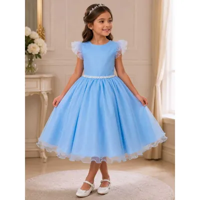 Menina com vestido azul claro de glitter, mangas de babado transparente, cinto de pérolas e saia rodada até a canela